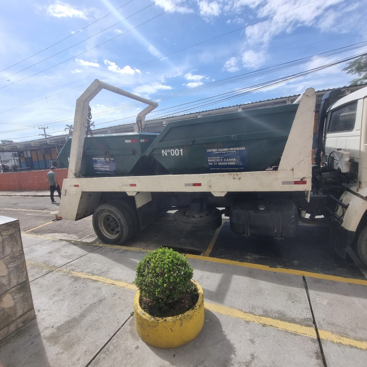 Caminhão SEG ENTULHO transportando caçamba
